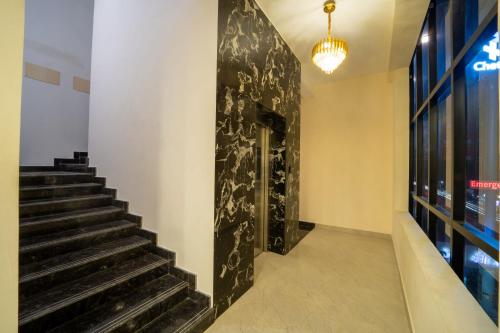 a staircase in a building with a black wall at VR PARADISE Inn in Kelambākkam
