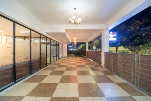 a hallway of a building with a checkerboard floor at VR PARADISE Inn in Kelambākkam