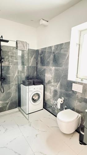 a bathroom with a washing machine and a toilet at Suite Fritz in Neuwied