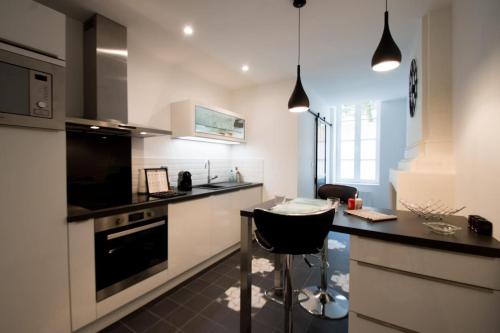 une cuisine avec un comptoir noir et un tabouret noir dans l'établissement Beautiful T2 hypercentre private courtyard, à La Rochelle