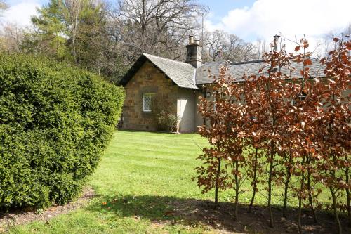a house with a yard with a bush in front of it at JOIVY The Lodge At Gilmerton House, North Berwick in North Berwick