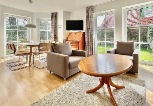 Una sala de estar con una mesa y un comedor. en 'Edes Huus', en Langeoog