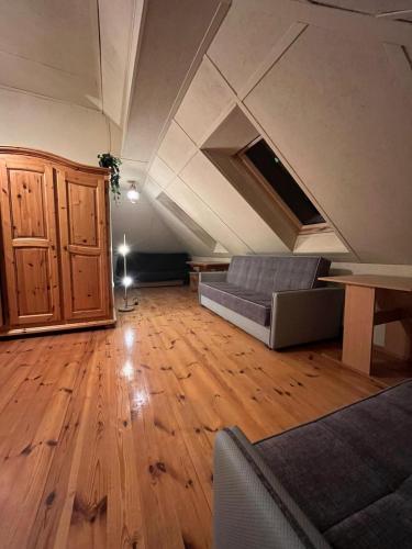 a living room with a couch and a wooden floor at Sands Dom Szteklin in Szteklin