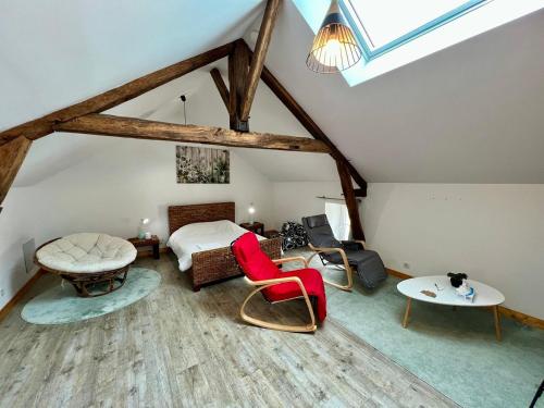 a attic room with a bed and a table and chairs at Chez Marcel - Maison 3 chambres in Lussac-les-Châteaux