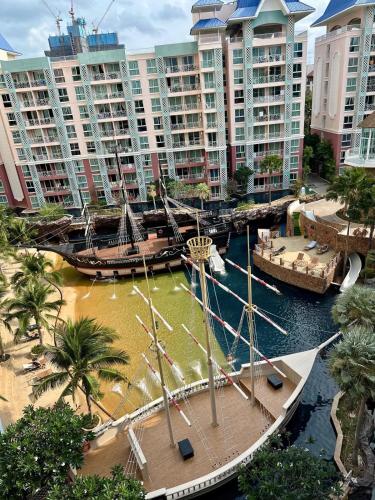 a large boat in a river with tall buildings at Accommodation with waterpark in Pattaya South
