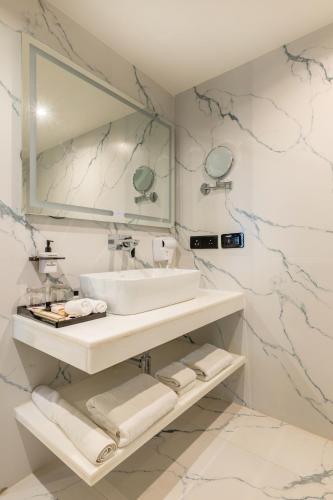 a white bathroom with a sink and a mirror at Pink Pearl Hotel By Chokhi Dhani in Jaipur