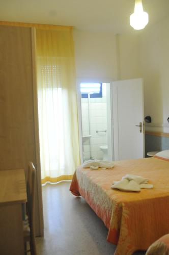 a hotel room with a bed with towels on it at Hotel Lux in Cesenatico