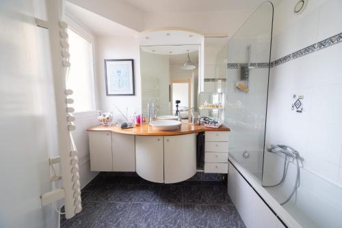 une salle de bain avec un lavabo, un miroir et une baignoire dans l'établissement Spacious Apt With Terrace And Parking, à Vanves