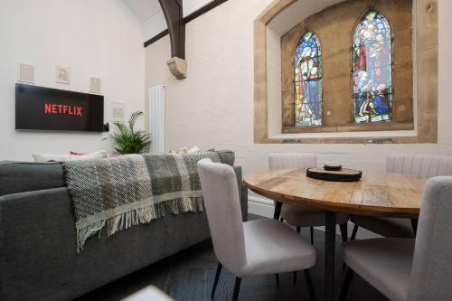 a living room with a couch and a table with chairs at The Spire! 1800s Church Rare Find Free Parking in Waterloo