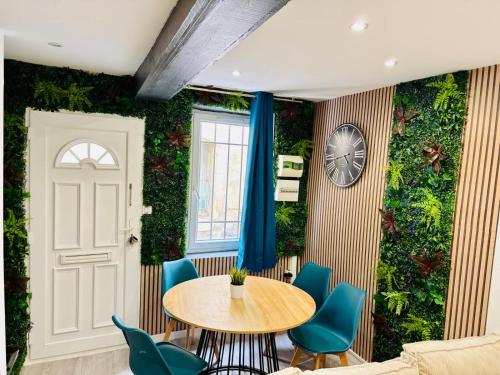 a dining room with a green wall with a table and chairs at Sereni house jacuzzi in Narbonne