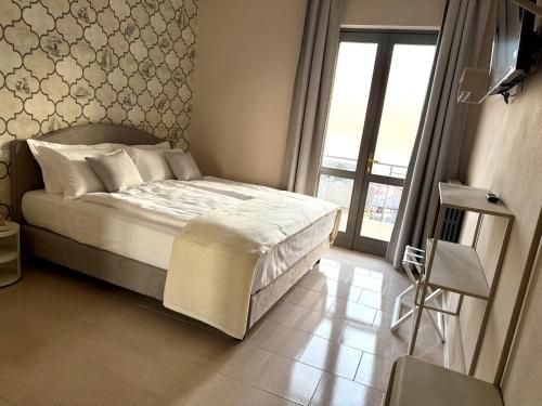 a bedroom with a bed and a large window at Hotel MioMio in Tignale