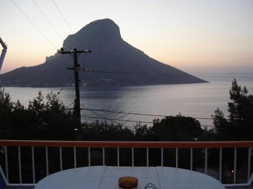 a table on a balcony with a view of a mountain at Tatsis Apartments in Masouri
