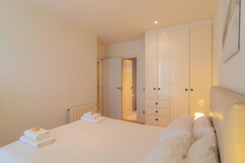 a white bedroom with a bed and a closet at Apartamento Holidea Parque las Llamas in Santander