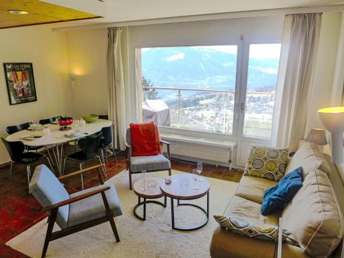 a living room with a couch and a table and a large window at Apartment Clair-Azur B 65 by Interhome in Randogne