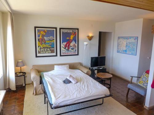 a bedroom with a bed and two posters on the wall at Apartment Clair-Azur B 65 by Interhome in Randogne