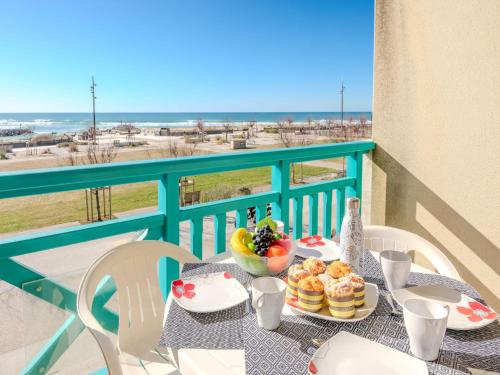 - une table avec de la nourriture sur un balcon avec vue sur la plage dans l'établissement Apartment L'Oustalet-3 by Interhome, à Mimizan-Plage