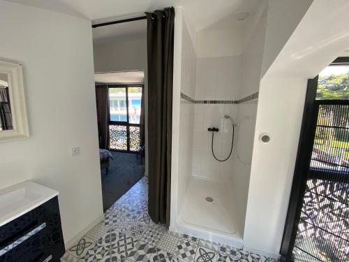 La salle de bains est pourvue d'une douche à l'italienne à côté d'une fenêtre. dans l'établissement Villa royal, à La Baule