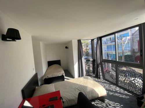 une chambre avec deux lits et une grande fenêtre dans l'établissement Villa royal, à La Baule