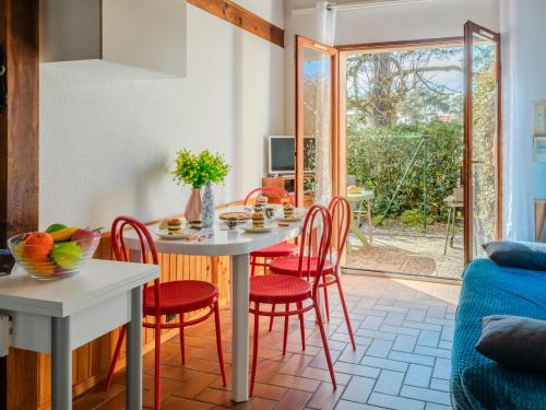 une salle à manger avec une table blanche et des chaises rouges dans l'établissement Apartment Les Landaises-5 by Interhome, à Mimizan-Plage