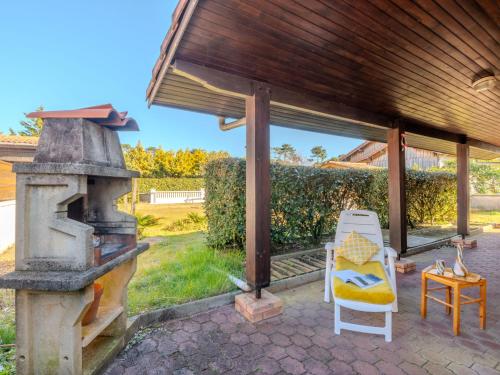 ミミザン・プラージュにあるHoliday Home Oyan Aldo by Interhomeの屋外パティオ(薪ストーブ、椅子付)