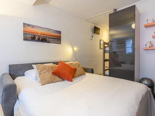 une chambre avec un grand lit blanc avec des oreillers orange dans l'établissement Apartment Maison Port En Dro-6 by Interhome, à Carnac