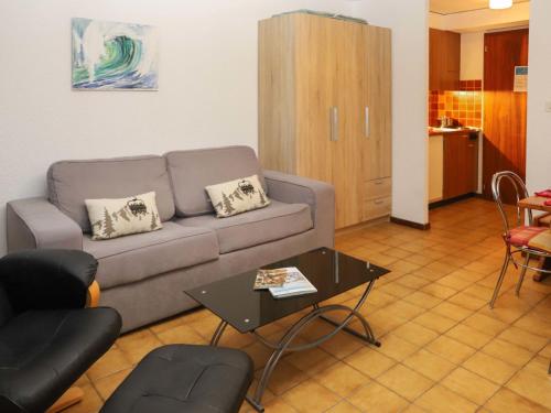 a living room with a couch and a table at Apartment Arnica 16 by Interhome in Nendaz