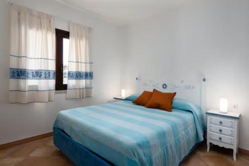 una camera da letto bianca con un letto blu e una finestra di Marina Maria a Murta Maria
