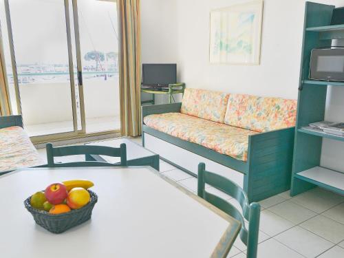 - un salon avec un canapé et une corbeille de fruits sur une table dans l'établissement Apartment L'Open-10 by Interhome, à Fréjus