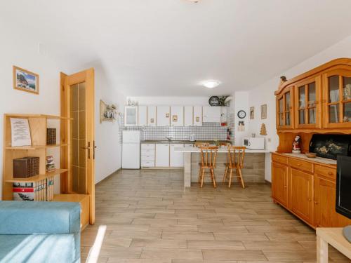 a kitchen with white cabinets and a table and chairs at Apartment Cesa Lucilla by Interhome in Canazei