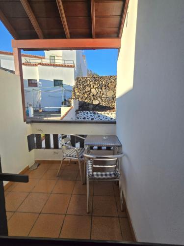 a balcony with a table and chairs on a balcony at Pensión Los Volcanes in Fuencaliente de la Palma