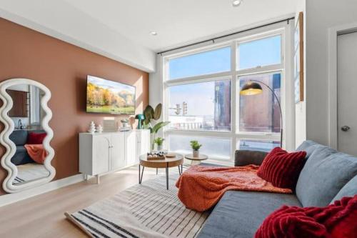 Una sala de estar con un sofá y una ventana grande. en Modern 1BR Near Metro - Walk to MET & Cafes - Free Parking, en Filadelfia