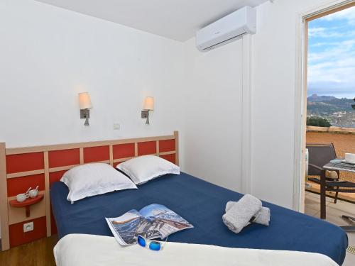 une chambre avec un lit bleu avec des serviettes dessus dans l'établissement Apartment Le Belvédère - R0 145 by Interhome, à Agay