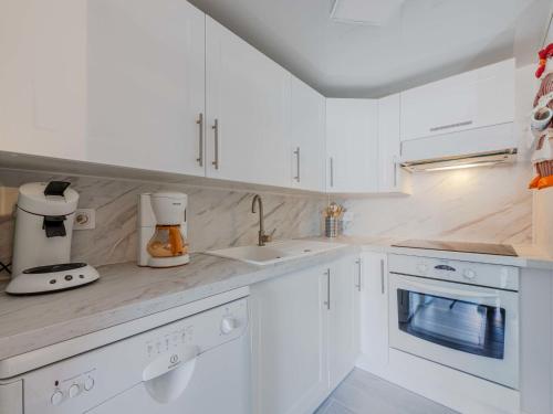 une cuisine blanche avec des placards blancs et un appareil dans l'établissement Holiday Home Santa Barbara-11 by Interhome, au Barcarès