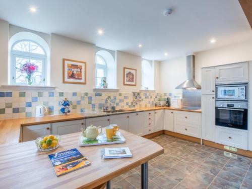 a kitchen with a wooden table and a counter top at Holiday Home Old Stables by Interhome in Drumnadrochit