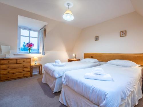 a bedroom with two beds and a window at Holiday Home Old Stables by Interhome in Drumnadrochit
