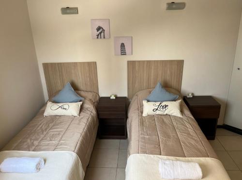 two beds in a room with two pillows at Dpto centrico in Santiago del Estero