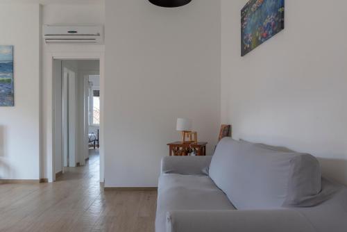 a living room with a white couch and a fireplace at Casa Del Mare 50 m dal mare - nuova - Pasqua in Maremma in Castiglione della Pescaia