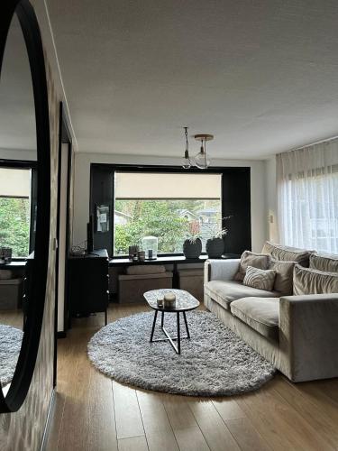 a living room with a couch and a table at Spacious Two Person Chalet in Hattemerbroek