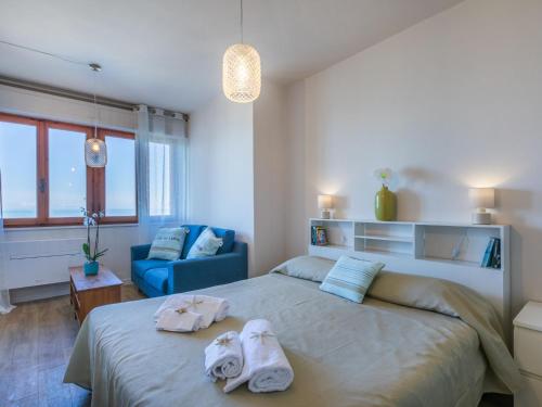 a bedroom with a large bed and a blue couch at Apartment Mediterraneo by Interhome in San Vincenzo