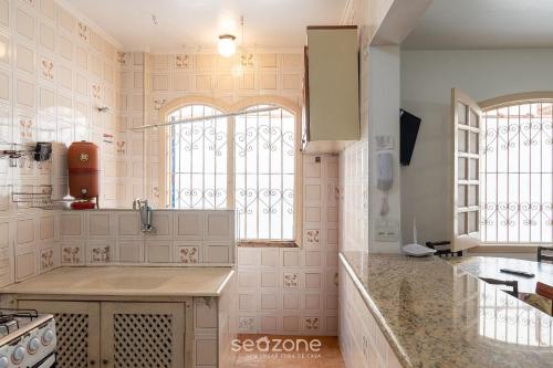 a kitchen with a sink and two windows at Elegante Apto a 260m da Praia Grande BTI003 in Ubatuba