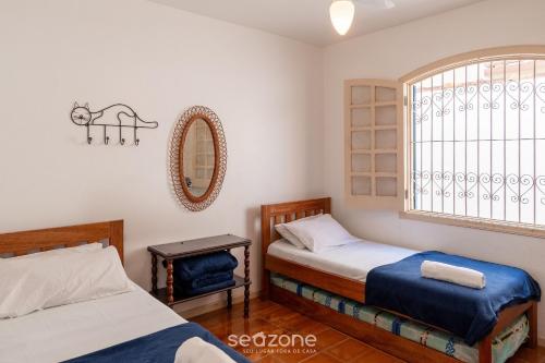 a bedroom with two beds and a window at Elegante Apto a 260m da Praia Grande BTI003 in Ubatuba