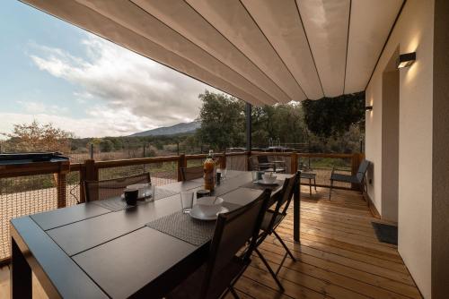 un patio avec une table et des chaises sur une terrasse dans l'établissement Gîtes du Soleil, à Sorède