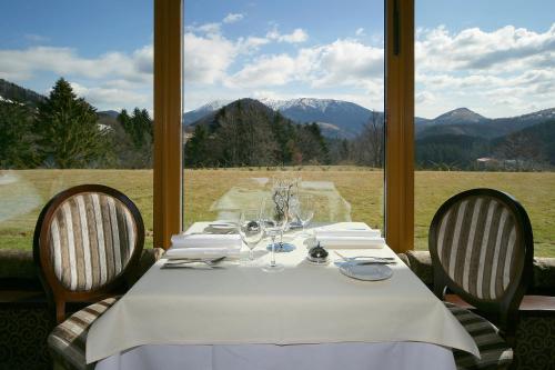 a table with a white tablecloth and two chairs with a view at Residence Hotel in Donovaly