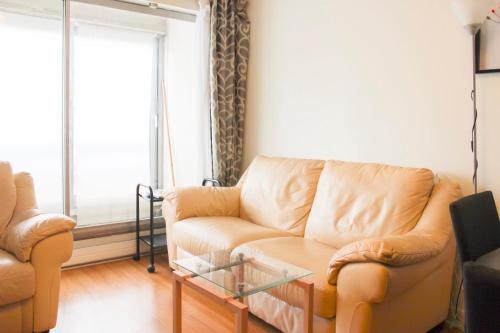 un salon avec un canapé et une table en verre dans l'établissement Spacious 3 rooms with balcony in Paris, à Paris