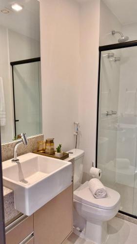 a white bathroom with a sink and a toilet at Apartment JC 903: Jardim Camburi. Vitória- E.S. in Carapina