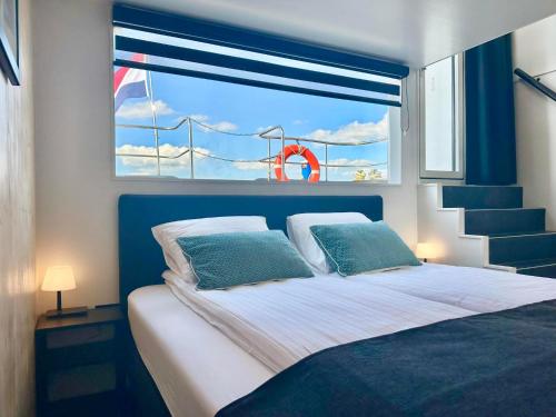 a bedroom with a large bed with a window at VaarLoft Pur Sang in Offingawier