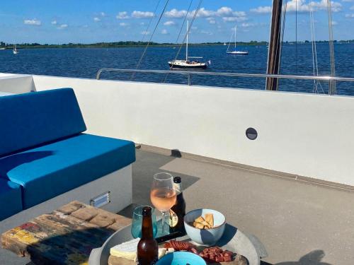 a table with a drink and food on a boat at VaarLoft Pur Sang in Offingawier
