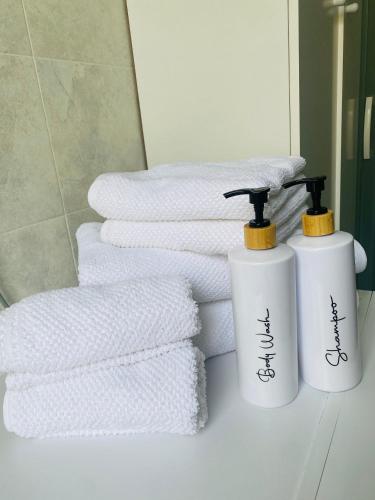 two white towels are sitting next to a pile of towels at Ca di nonni in Ortovero