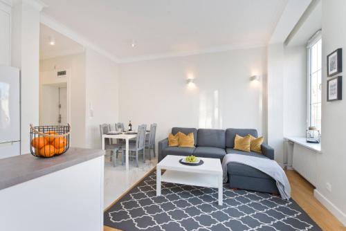 Una sala de estar con un sofá azul y una mesa. en YOURAPART Piwna Luxury Apartment, en Gdansk