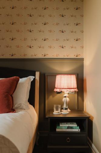 a bedroom with a bed and a lamp on a nightstand at Cartmel Old Grammar in Cartmel